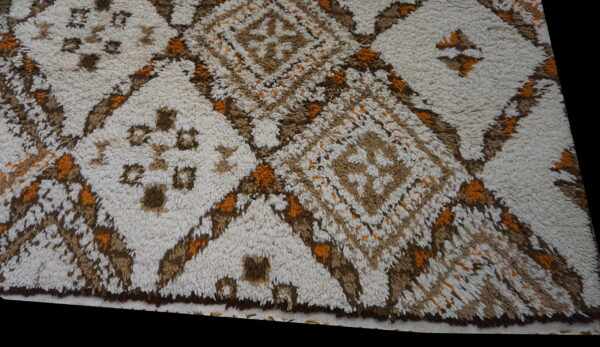High-pile rug featuring a geometric diamond pattern in cream, brown, and bright orange colors.