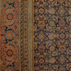 Intricate traditional rug with a rust border and navy central field showing distressed gold and teal patterns.