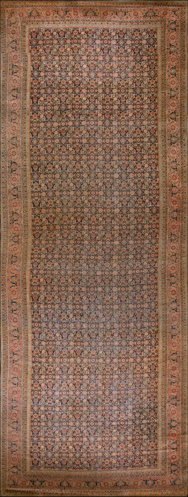 Traditional dark rug with a dense repeating floral pattern and wide ornate border in muted orange and peach tones.