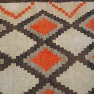 Geometric flatweave rug featuring stepped diamonds outlined in brown and filled with orange and natural beige.