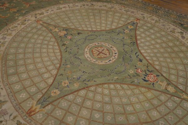 Sage green neoclassical rug with intricate floral designs, decorative garlands, and a pale diamond trellis motif.