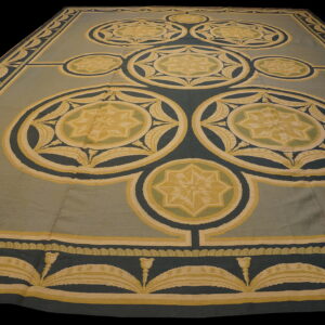 Flatwoven rug featuring large geometric star medallions in teal, gold, and sage green colors.