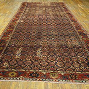 Traditional red and navy runner rug with complex geometric patterns displayed on light wood plank flooring.
