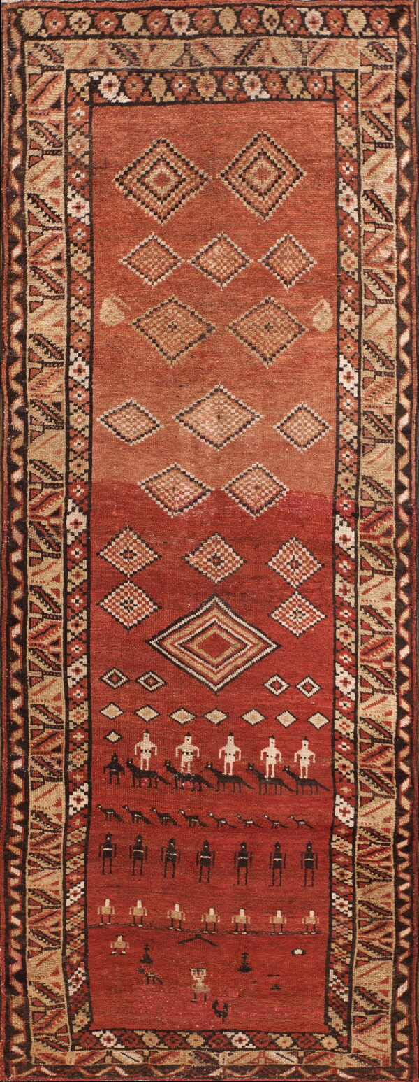 Red and tan runner rug featuring abrash, geometric diamonds, and rows of stylized figures within the field.