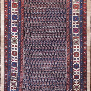 Dark blue runner rug with repeating stylized motifs and intricate multi-colored borders in red, blue, and white.