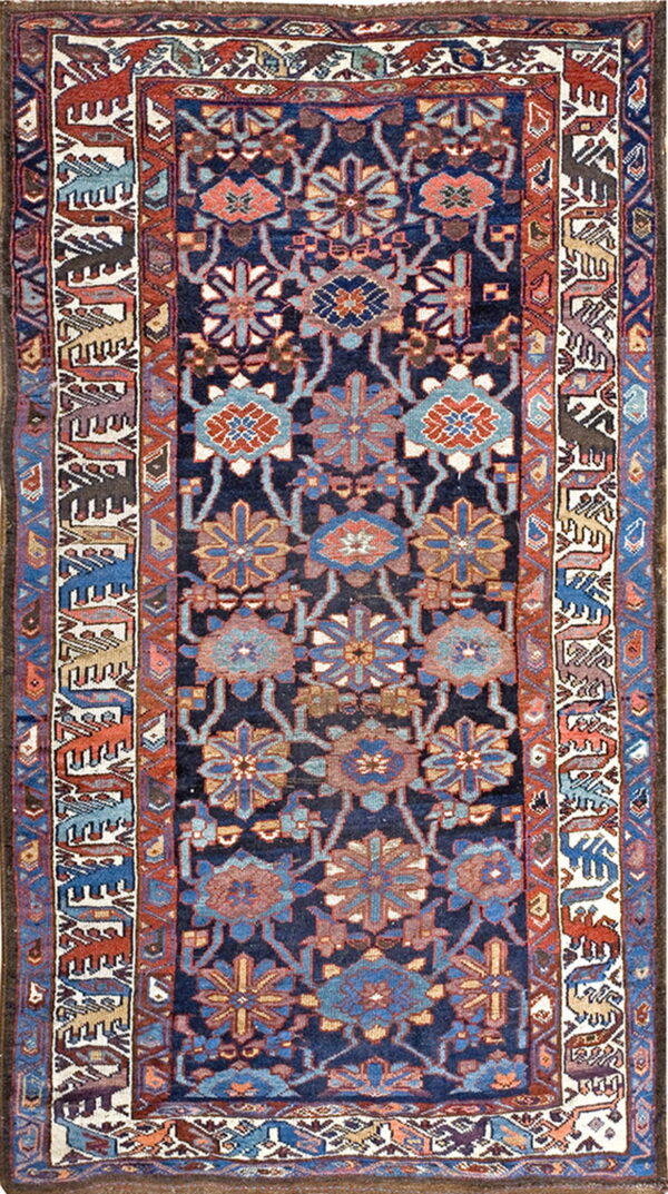 Navy rug with repeating medallions in blue and rust, framed by borders depicting geometric animals on ivory.