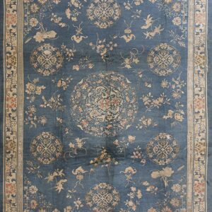Muted blue rug featuring an elaborate traditional design of birds, pink flowers, and central medallions within a beige border.