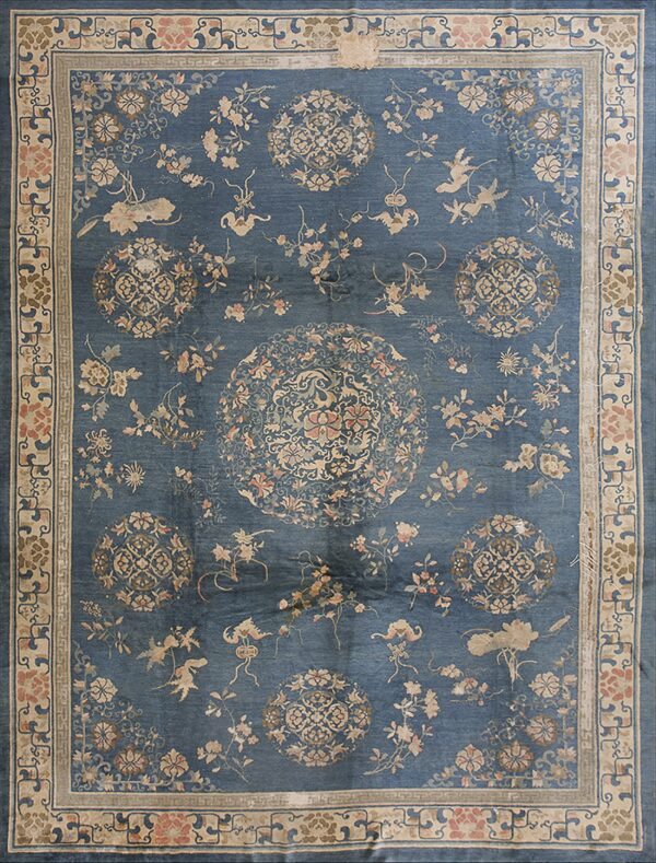 Muted blue rug featuring an elaborate traditional design of birds, pink flowers, and central medallions within a beige border.