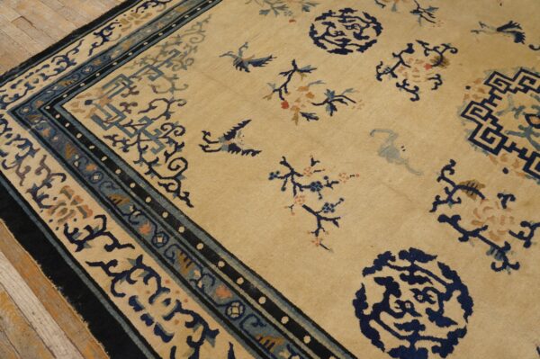 Beige rug featuring navy, teal, and tan scattered medallions, birds, and complex borders on wood floor.