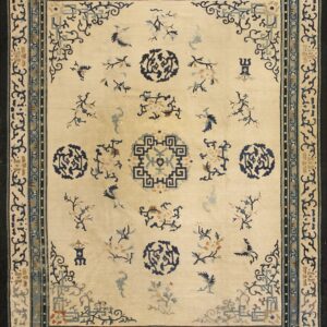 Ivory rug with scattered stylized blue, teal, and tan motifs framed by intricate dark blue borders.