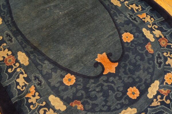 High-pile indigo and teal rug featuring stylized orange, tan, and brown floral motifs.