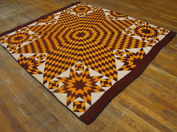 Brown, gold, and white geometric star pattern textile rests flatly on distressed wood plank flooring.