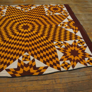 Flat geometric rug with quilted texture, featuring brown, mustard, and cream star patterns on distressed wood floors.
