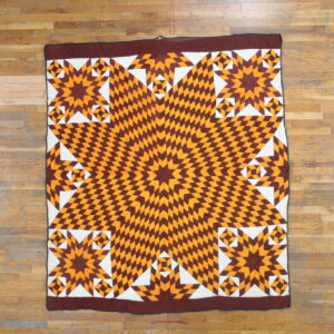 Low-profile textile with a geometric brown, orange, and white star pattern on wood flooring.