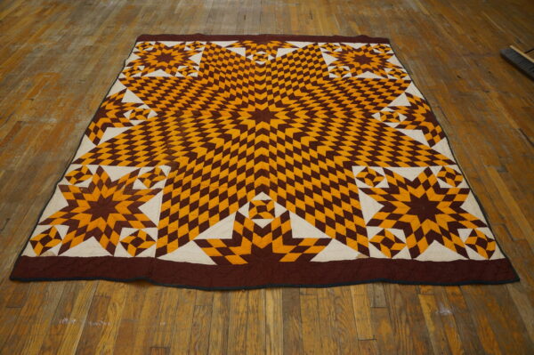 Low-profile textile featuring a geometric star pattern in brown, gold, and cream on rustic wood flooring.