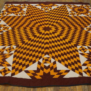 Geometric textile rug with large star motifs in brown and yellow diamonds, centered on wood floors.