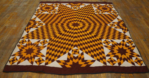 Geometric textile rug with large star motifs in brown and yellow diamonds, centered on wood floors.