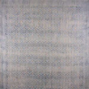 Muted blue distressed rug with a lattice floral pattern, tan accents, and a Greek key border.