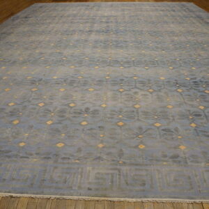 Blue rug featuring an all-over floral pattern, yellow diamond details, and a wide Greek key border.