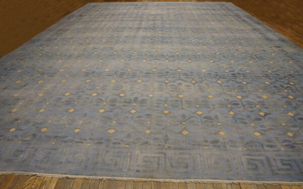 Blue rug featuring an all-over floral pattern, yellow diamond details, and a wide greek key border.