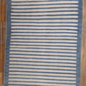 Low-pile rug with blue and off-white horizontal stripes tapering to points at the blue border.