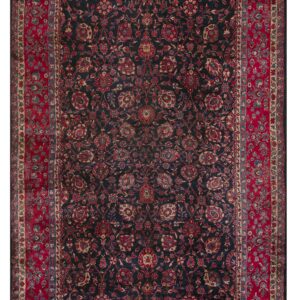 Navy rug with elaborate red, blue, and gold floral patterns surrounded by a wide primary red border.