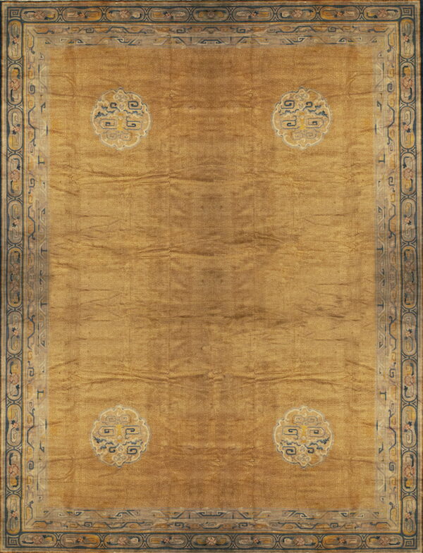 A gold low-pile rug with a tone-on-tone meander field pattern and four cream and blue corner medallions.
