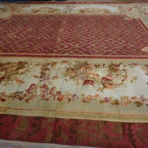 Large traditional rug featuring a red medallion field and wide light floral borders on wood planks.