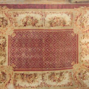 Cream and burgundy low-pile rug featuring a central trellis design and detailed fruit and floral borders.