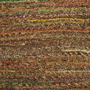 Shaggy multicolor rug texture displays brown flecks mixed with vivid horizontal stripes on a wood floor.