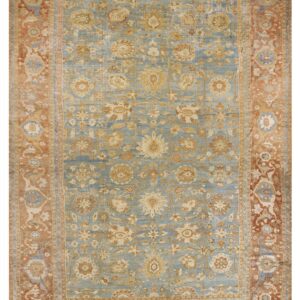 Ornate floral rug with a pale blue field and a wide brick red patterned border.