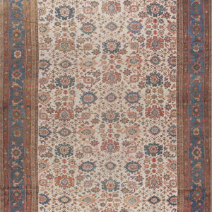 Cream rug with dense rust and blue all-over floral pattern and wide indigo outer borders.