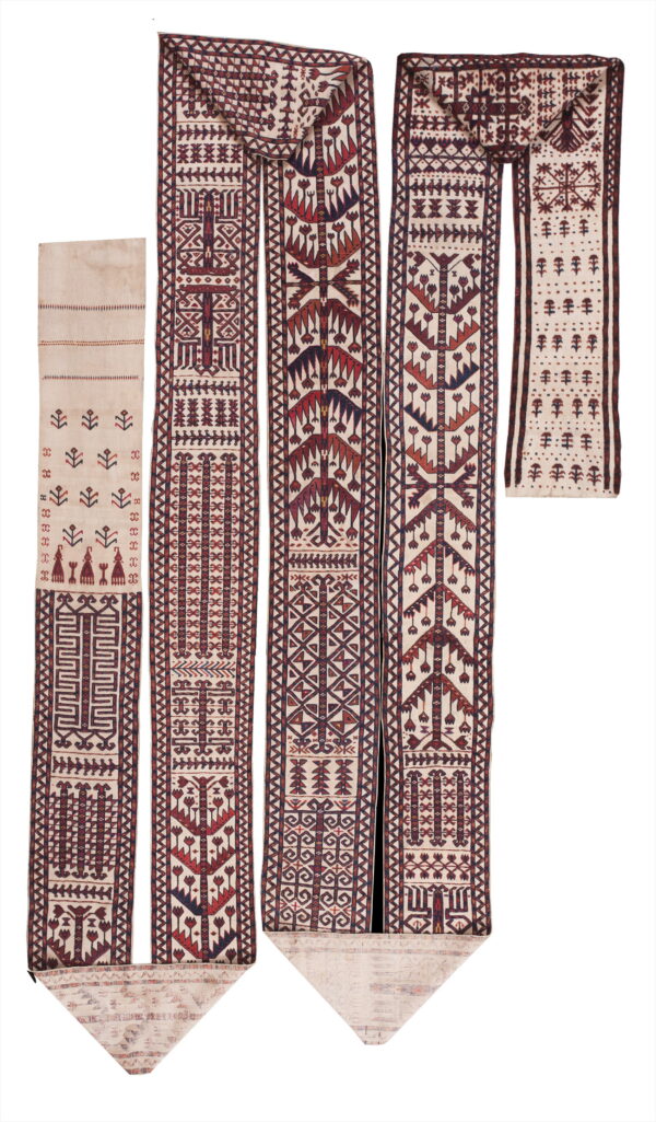 Four flatweave textiles with geometric and stylized tree motifs in cream, red, and indigo colors.