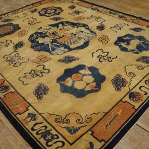 Low-pile tan rug featuring navy and orange traditional figures, clouds, and bordered medallions on wood planks.