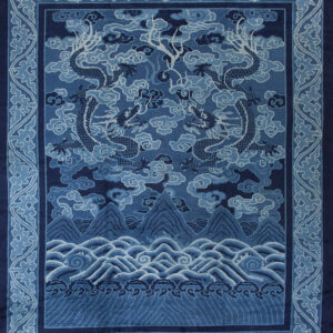 A dark blue rug featuring two dragons flying over mountains and waves, surrounded by a cloud border.