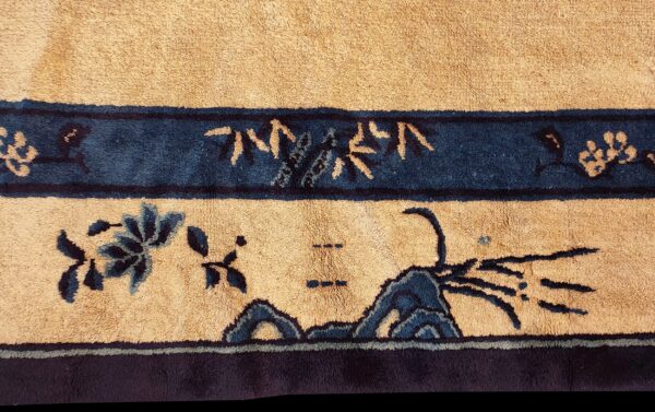 High-pile beige rug with dark blue floral and landscape motifs in stacked horizontal borders.