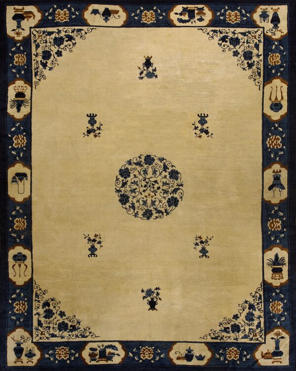 Light beige rug featuring a dark blue central floral medallion and a wide border with stylized object motifs.