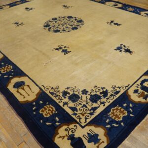 Cream rug with a blue medallion and detailed border sits on rustic wood plank flooring.