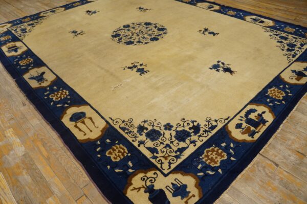 Cream rug with a blue medallion and detailed border sits on rustic wood plank flooring.