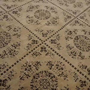 Beige rug with dark brown ornamental medallions inside a repeating square grid pattern.