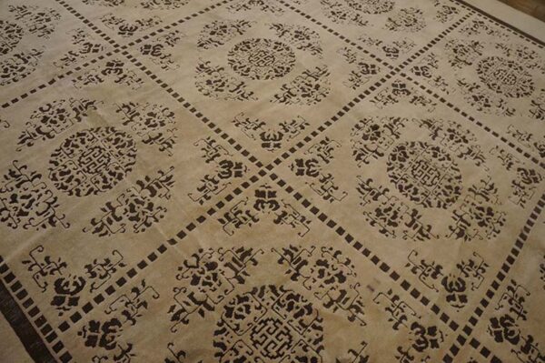 Beige rug with dark brown ornamental medallions inside a repeating square grid pattern.