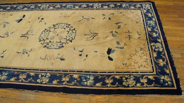 Antique peking chinese floral beige 1890s rug 5 Traditional beige and navy blue rug with pink and light blue floral patterns on a wood floor.