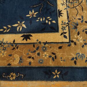 High-pile rug in deep indigo and gold features floral borders, visible over worn hardwood.