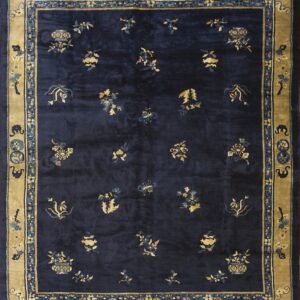 Navy blue area rug with scattered gold floral medallions and a wide, intricately patterned tan border.