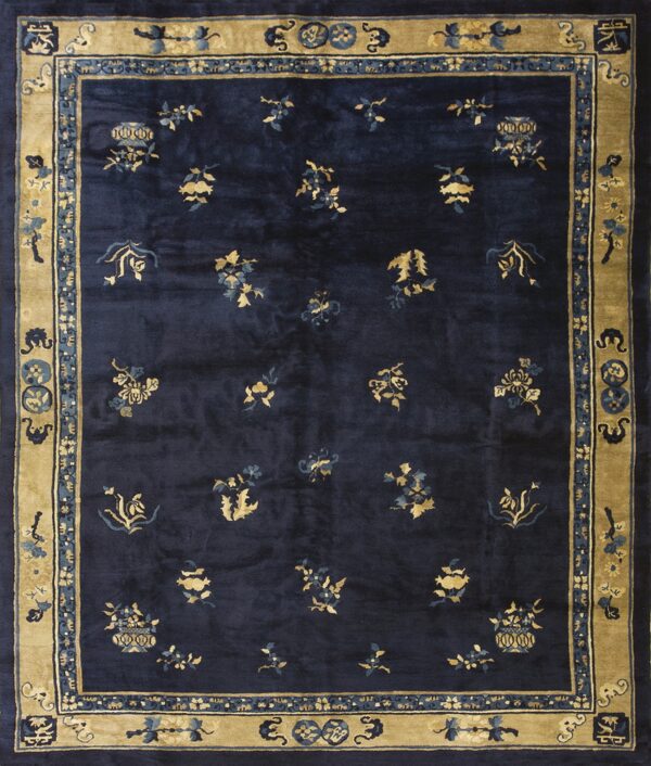 Navy blue area rug with scattered gold floral medallions and a wide, intricately patterned tan border.