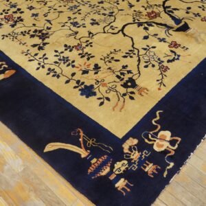 Gold field rug featuring an ornate blue floral tree design and detailed corner border on wood floors.