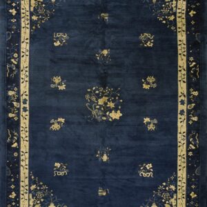 Low pile dark blue rug featuring contrast pale yellow blossoms and an ornate layered border design.