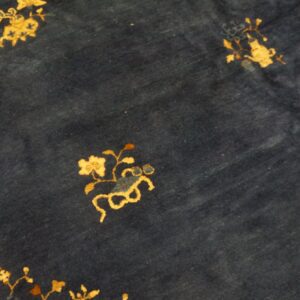 Stylized gold floral patterns scattered across a plush dark blue rug surface.