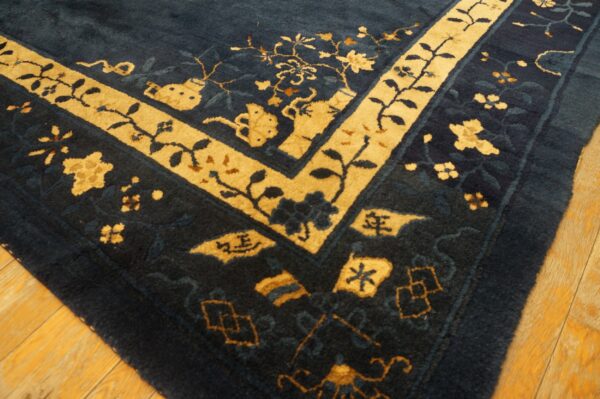 A thick, plush blue rug with intricate gold borders and floral patterns rests on golden hardwood flooring.