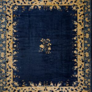 Navy blue rug with a central cream floral spray and broad borders of cream and multi-toned blue floral motifs.